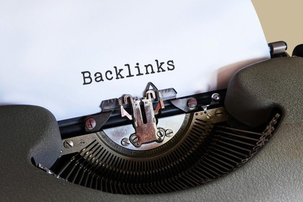 Close-up of a vintage typewriter printing the word 'Backlinks,' emphasizing content and SEO concepts.